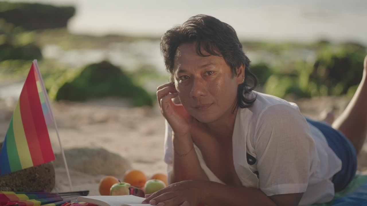 Man relaxing on a beach, reading a book and enjoying the sun