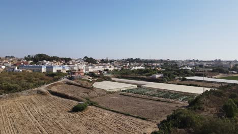 aerial view of a spanish town with greenhouses and fields