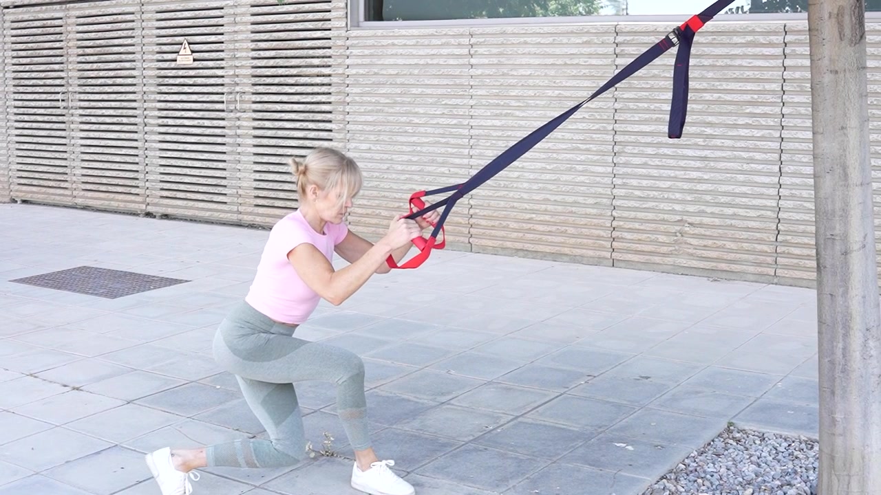 Woman is doing trx workout outdoors to stay active and fit with cardio and strength training