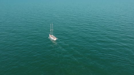 Luftaufnahme-Eines-Weißen-Segelboots-In-Der-Ruhigen-Ostsee,-Weiße-Segelyacht-Mitten-Im-Grenzenlosen-Meer,-Sonniger-Sommertag,-Weitwinkelaufnahme-In-Vorwärtsbewegung,-Nach-Unten-Geneigt