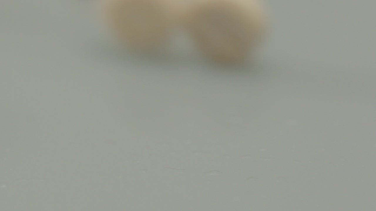 una sola píldora rodando hacia la cámara y de pie en el lado