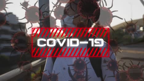 Animation-Des-Wortes-„Covid-19“-In-Weißen-Buchstaben-über-Einer-Frau,-Die-Eine-Maske-Auf-Der-Straße-Trägt