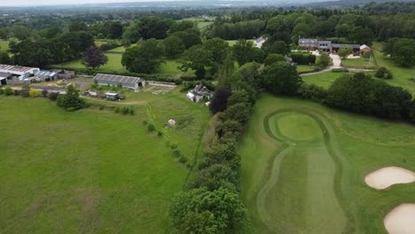 Statische-Drohnenaufnahme,-Die-Eine-Heckenreihe-Zwischen-Zwei-Golfplätzen-Mitten-In-Der-Englischen-Landschaft-Zeigt