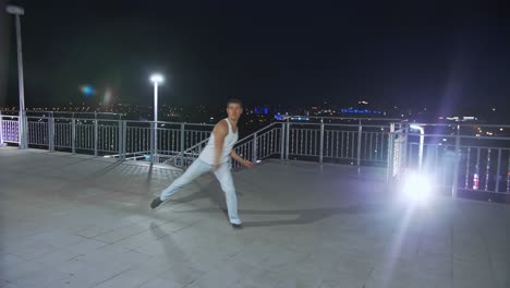 man dancing on a rooftop at night