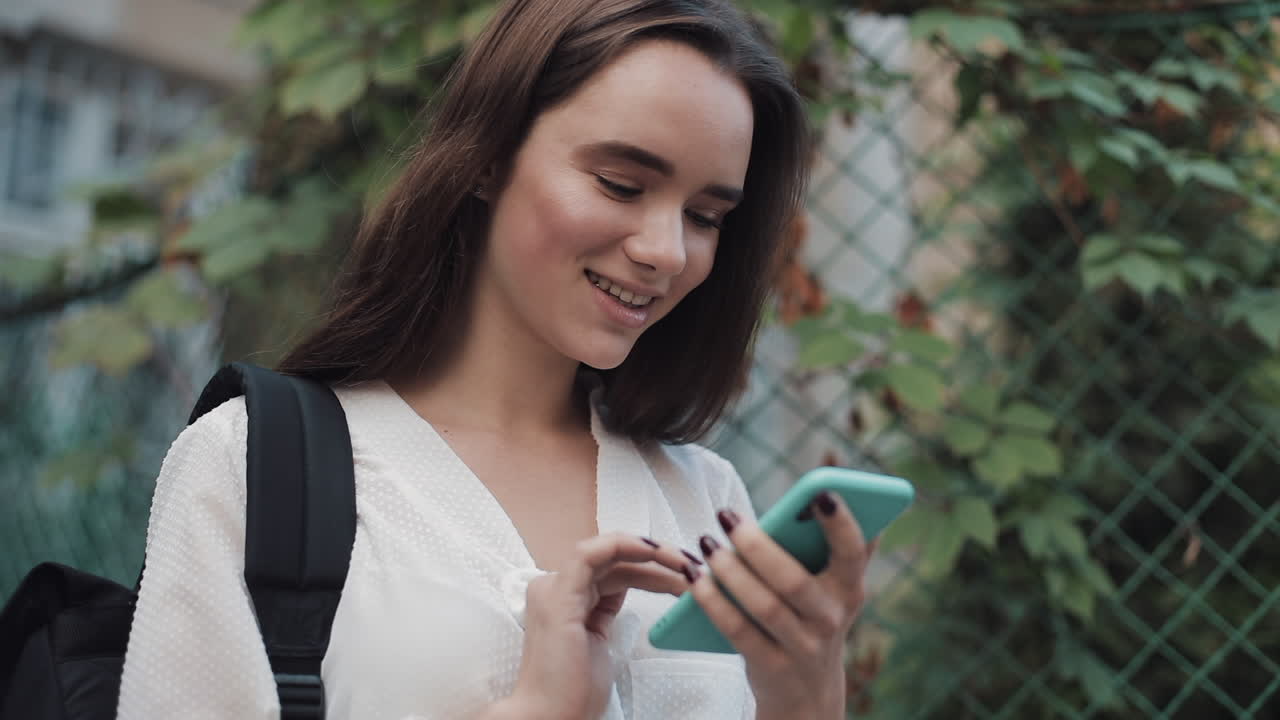 mujer joven usando teléfono móvil al aire libre