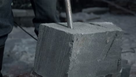 breaking concrete block with jackhammer