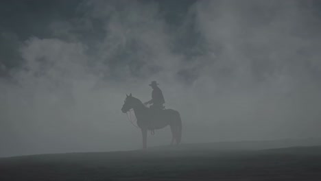 cowboy on horseback in a misty landscape
