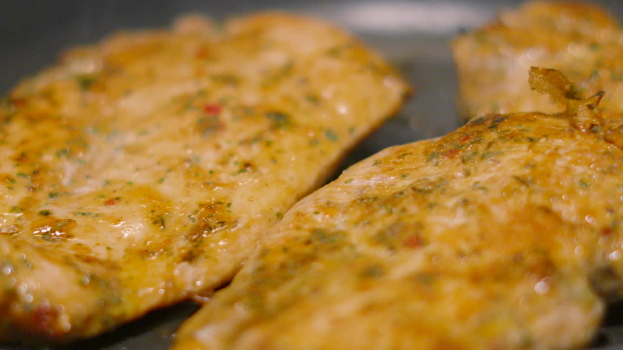 Moving Close Up of Chinese Chicken Steak Fillets Cooking and Sizzling in Hot Frying Pan in Kitchen. Food Photography Footage 4K.