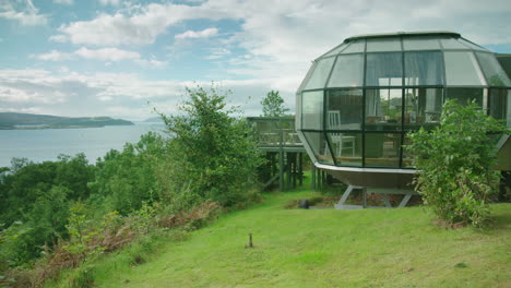 Toma-Panorámica-Desde-Una-Casa-Moderna-Hasta-El-Agua,-En-Un-Día-Ventoso