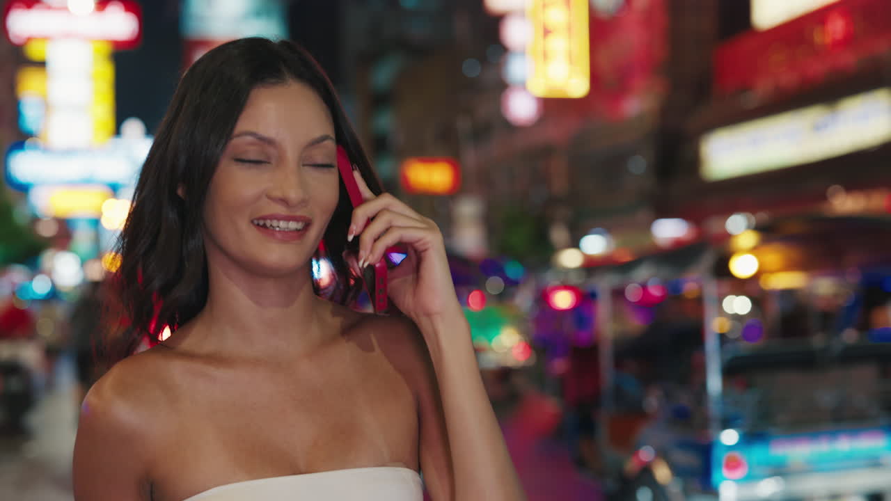 Woman on a phone call in a vibrant night market