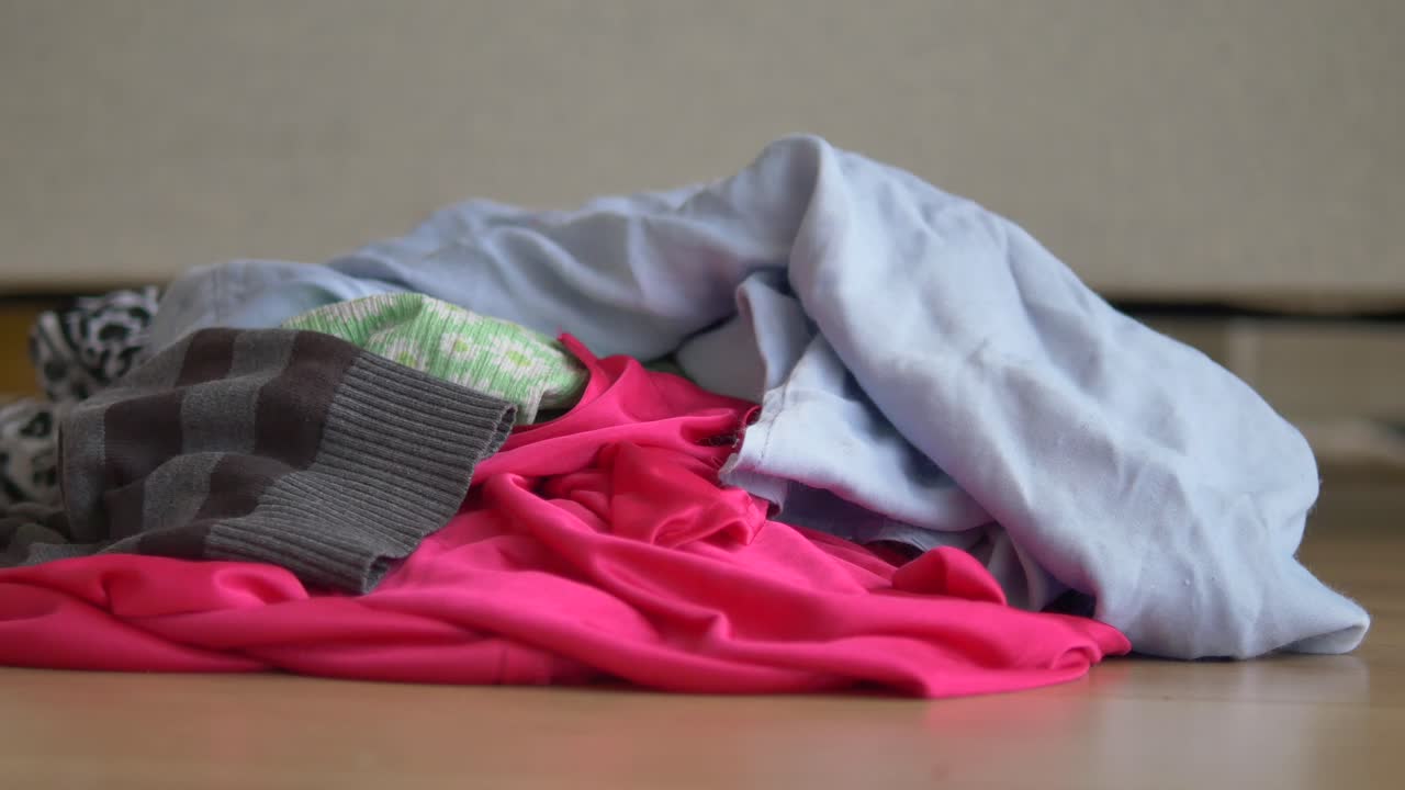 Pile of Dirty Laundry on Wooden Floor