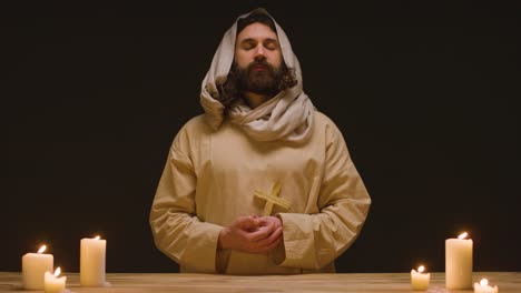 Studio-Shot-Of-Man-Wearing-Robes-Representing-Figure-Of-Jesus-Christ-Holding-Wooden-Cross-2