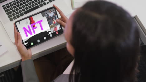 biracial businesswoman using tablet for video call with diverse business colleagues