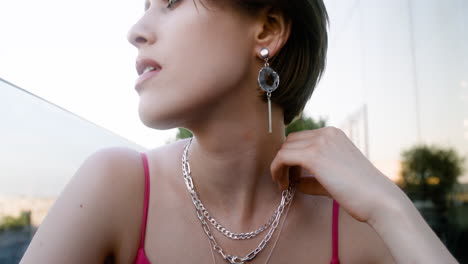 close-up view of elegant woman touching her necklace in red dress