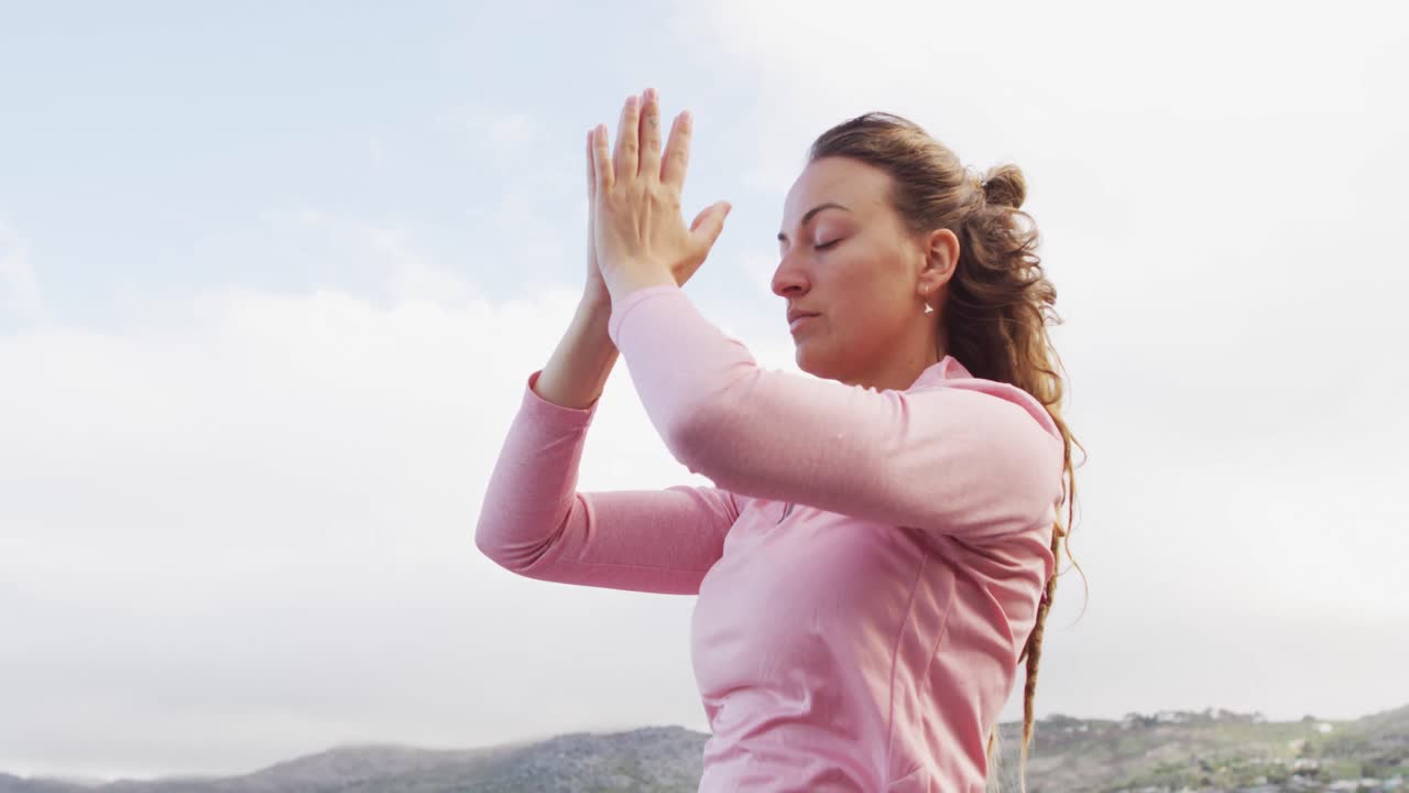 mujer caucásica practicando meditación de yoga al aire libre en un entorno montañoso rural