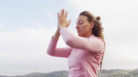 Caucasian-woman-practicing-yoga-meditation-outdoors-in-rural-mountainside-setting