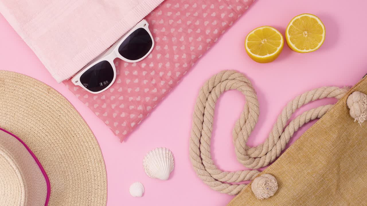 Accessori estivi creativi si muovono su uno sfondo rosa pastello di tendenza. Stop motion.