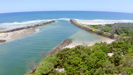 vista de la playa costera con personas nadando y relajándose