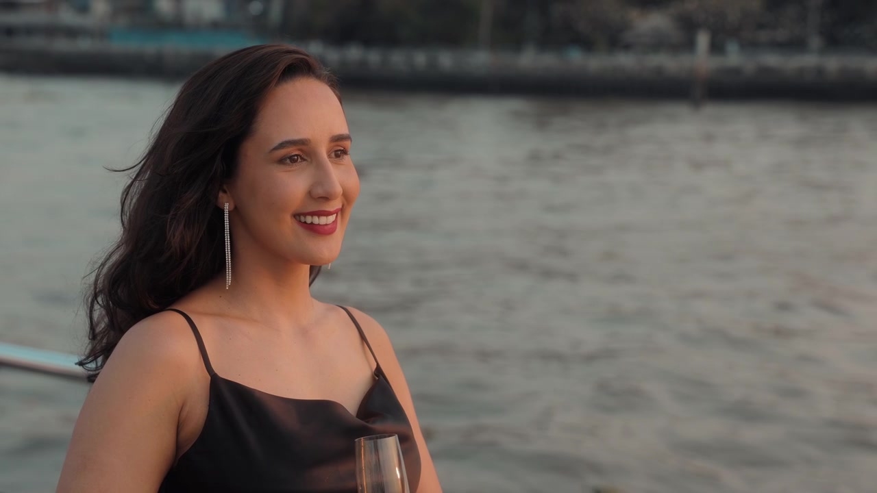 Donna elegante che sorseggia champagne su una barca al tramonto