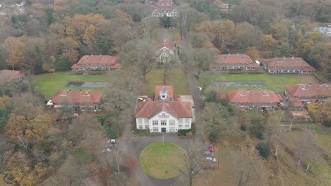 wide jib down of old mansion in small town in autumn