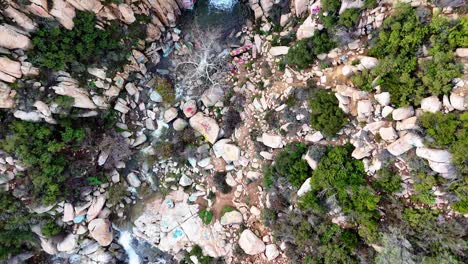 Luftaufnahme-Eines-Wasserfalls-Mit-Graffiti-Und-Markierten-Felsen-Drumherum