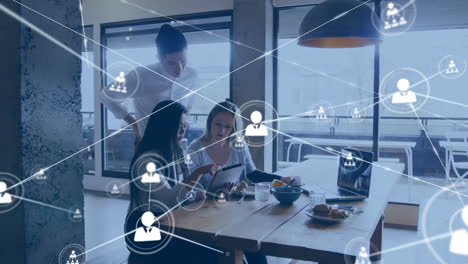 animation of connected people icons, diverse female coworkers analyzing report over tablet in office
