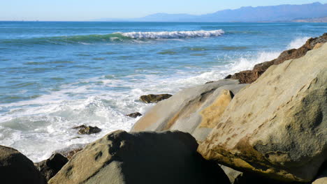 Eine-Meereswelle-Kracht-Und-Rutscht-In-Zeitlupe-Gegen-Einen-Felsigen-Kalifornischen-Strand-Nach-Rechts