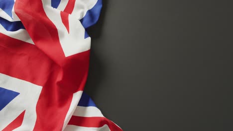 Video-Einer-Zerknitterten-Britischen-Flagge,-Die-Auf-Schwarzem-Hintergrund-Liegt