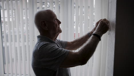 elderly man looking out window