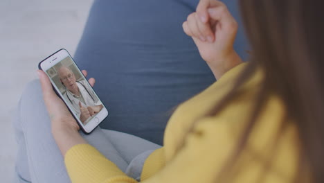 médico o terapeuta ayudan a aliviar el estrés de la crisis de coronavirus videoconferencia llamada en línea conversación en vivo de forma remota con la mujer sentarse en el sofá en casa usando una consulta médica de teléfono inteligente.
