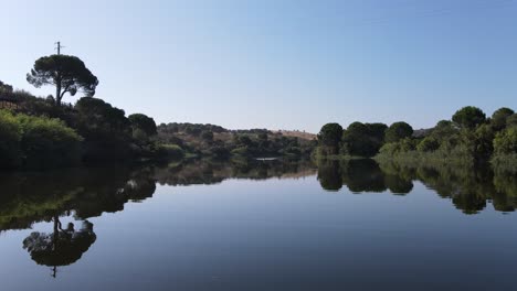 imágenes de un hombre navegando en canoa por una presa con reflejos en el agua.