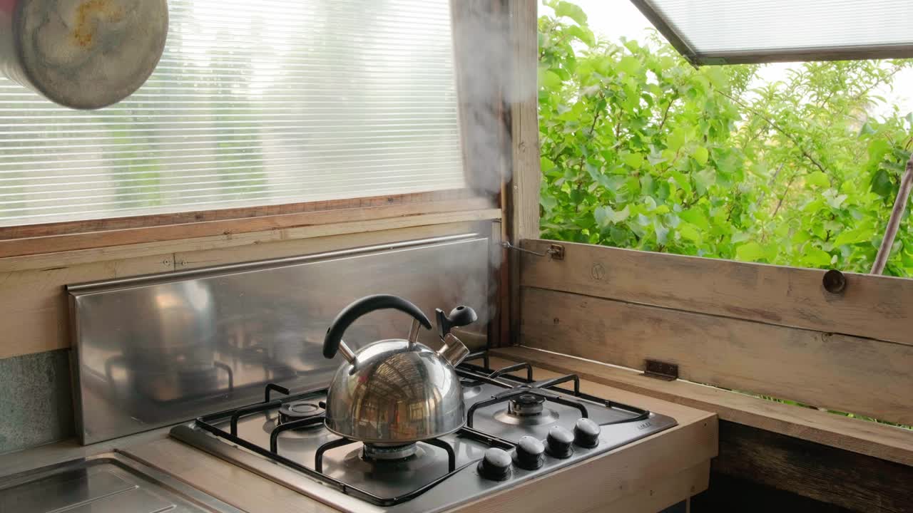 Steam coming out of the kettle in summer countryside kitchen.