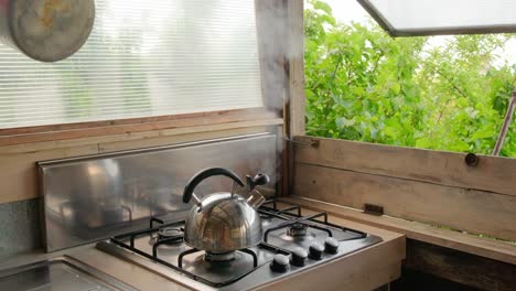 steam coming out of the kettle in summer countryside kitchen.