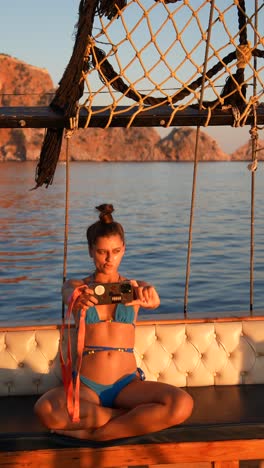 mujer tomando una selfie en un barco al atardecer