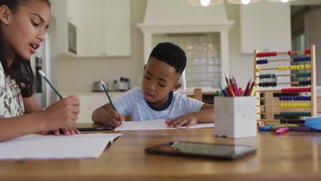 Afroamerikanische-Schwester-Und-Bruder-Sitzen-Am-Küchentisch-Und-Machen-Hausaufgaben