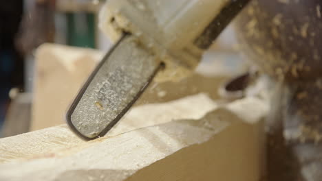 wood shavings fly as woodworker use chainsaw to carves wooden log