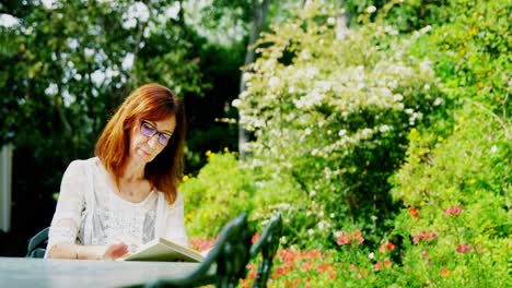 Mature-woman-reading-a-book-in-the-garden-4k