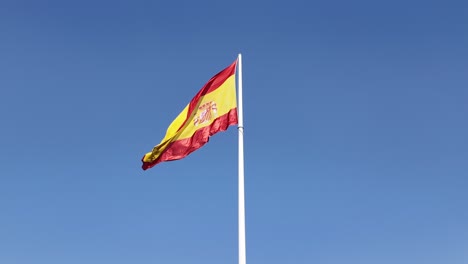 national spanish flag waving in a smooth wind in a white mast