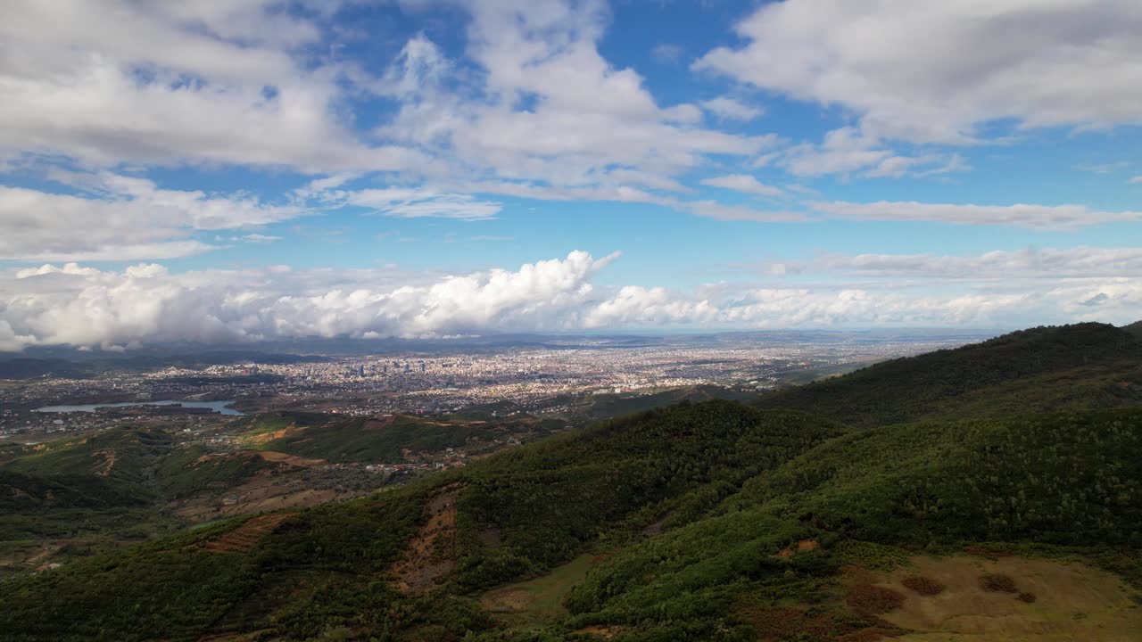 gran ciudad detrás de verdes colinas en un día nublado en otoño en tirana