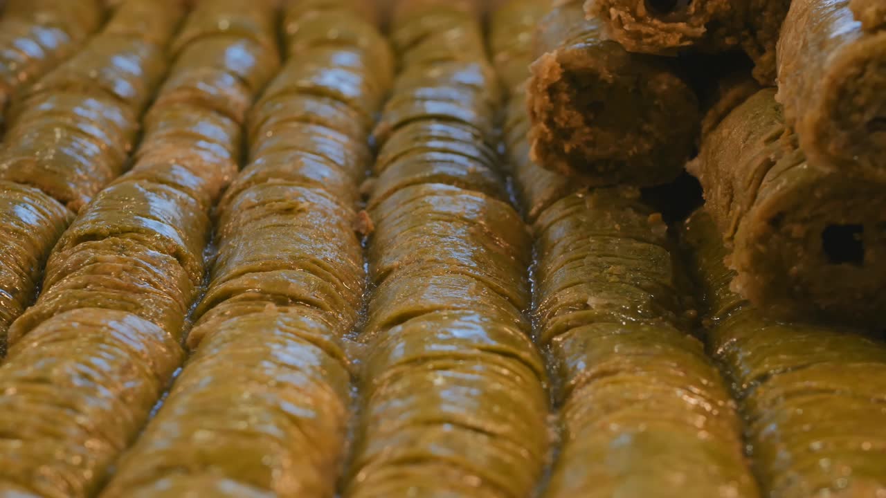 baklava turca con pasta de pistacho y relleno de pistacho sarma. baklava turco verde. video de muñecas. primer plano. 4k