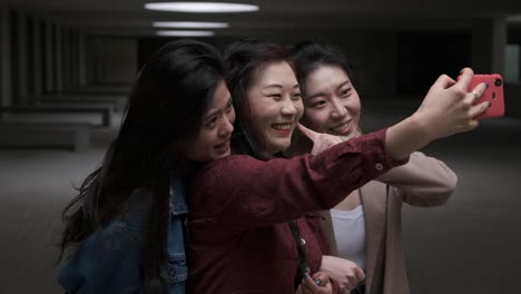 portrait of a group of asian women friends taking a selfie with a mobile phone together.
