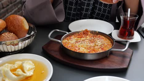 a delicious turkish breakfast of menemen, bread, and tea.