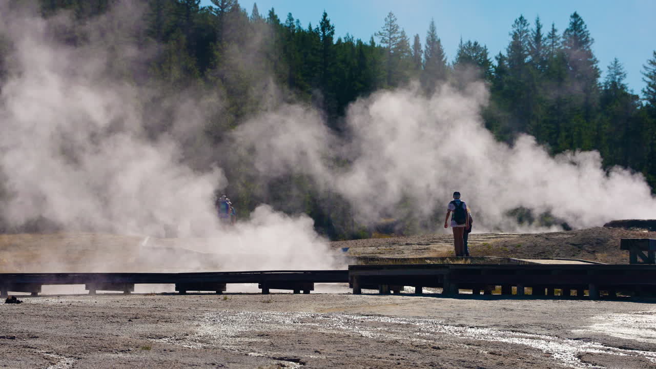 People observing steam at a geothermal area in Yellowstone National Park