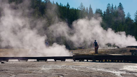 people observing steam at a geothermal area in yellowstone national park