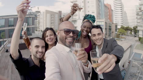 pov of boss with employees raising glasses of beverage at camera