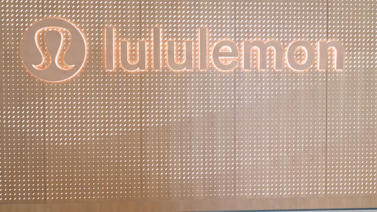 Shoppers walk past the Canadian sportswear brand Lululemon store at a shopping mall in Hong Kong.