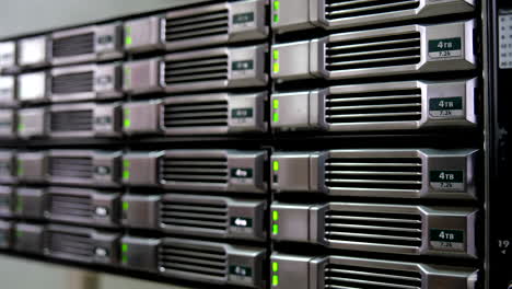 close-up of 4tb hard drives in a server rack with green indicator lights