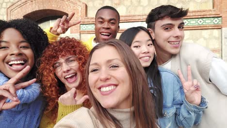smiling multi-ethnic friends gesturing while taking a selfie outdoors