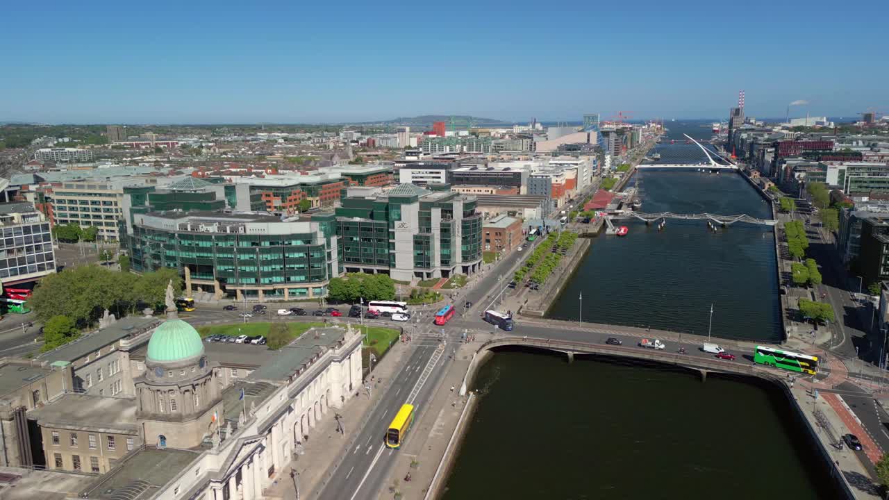 Forward travelling aerial video of Custom House, the River Liffey and the surrounding area in Dublin, Ireland, on a bright and sunny day. Filmed in 4K, 60FPS and with Rec709 color.