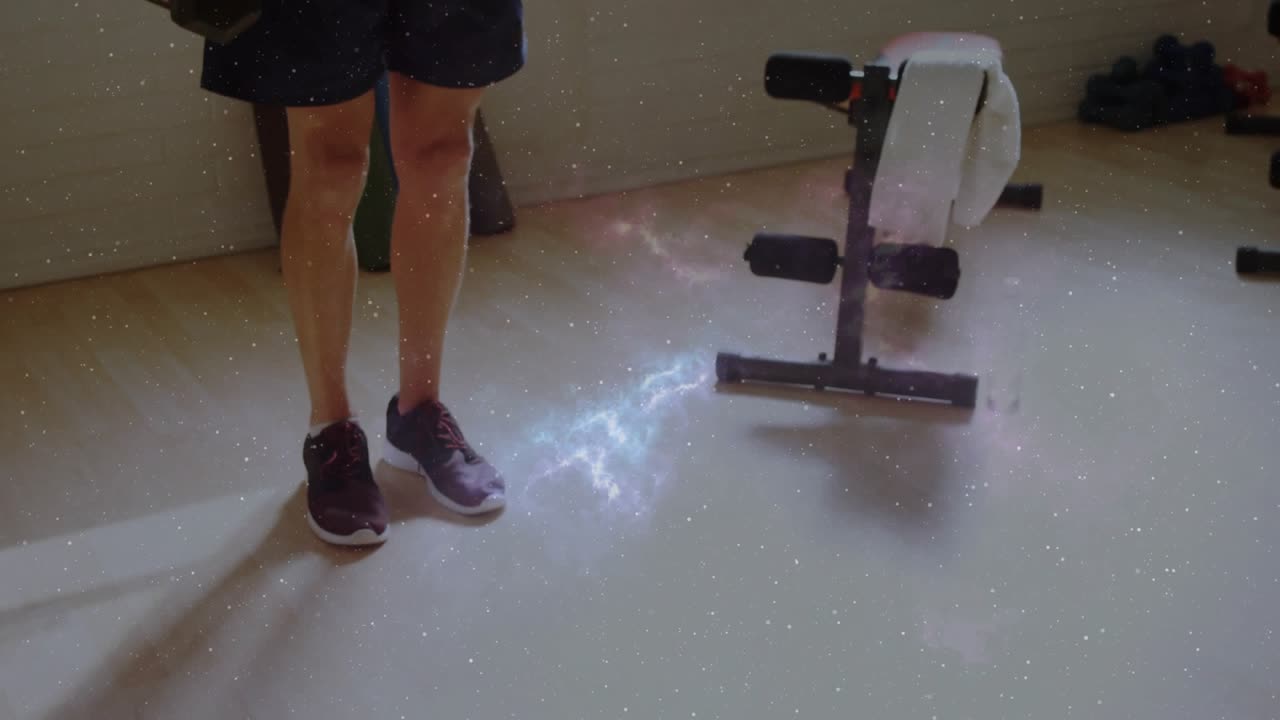 Man shifting weight and lunging forward with dumbbells, galaxy flare highlighting form for fitness